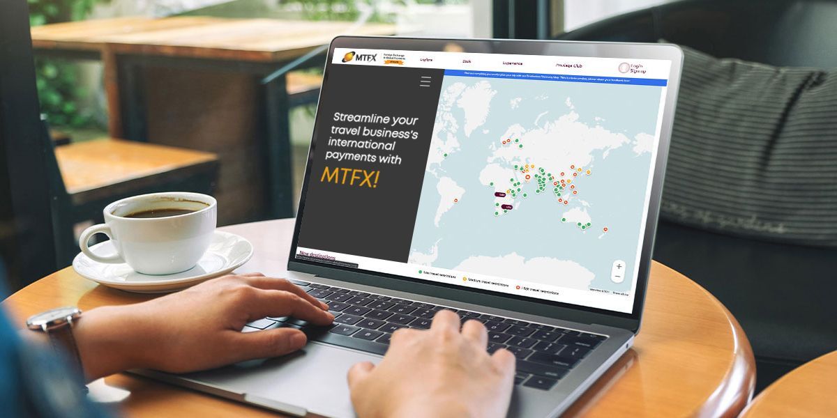 Person using laptop displaying MTFX platform for managing international payments in the travel industry, with a world map and payment routing interface.