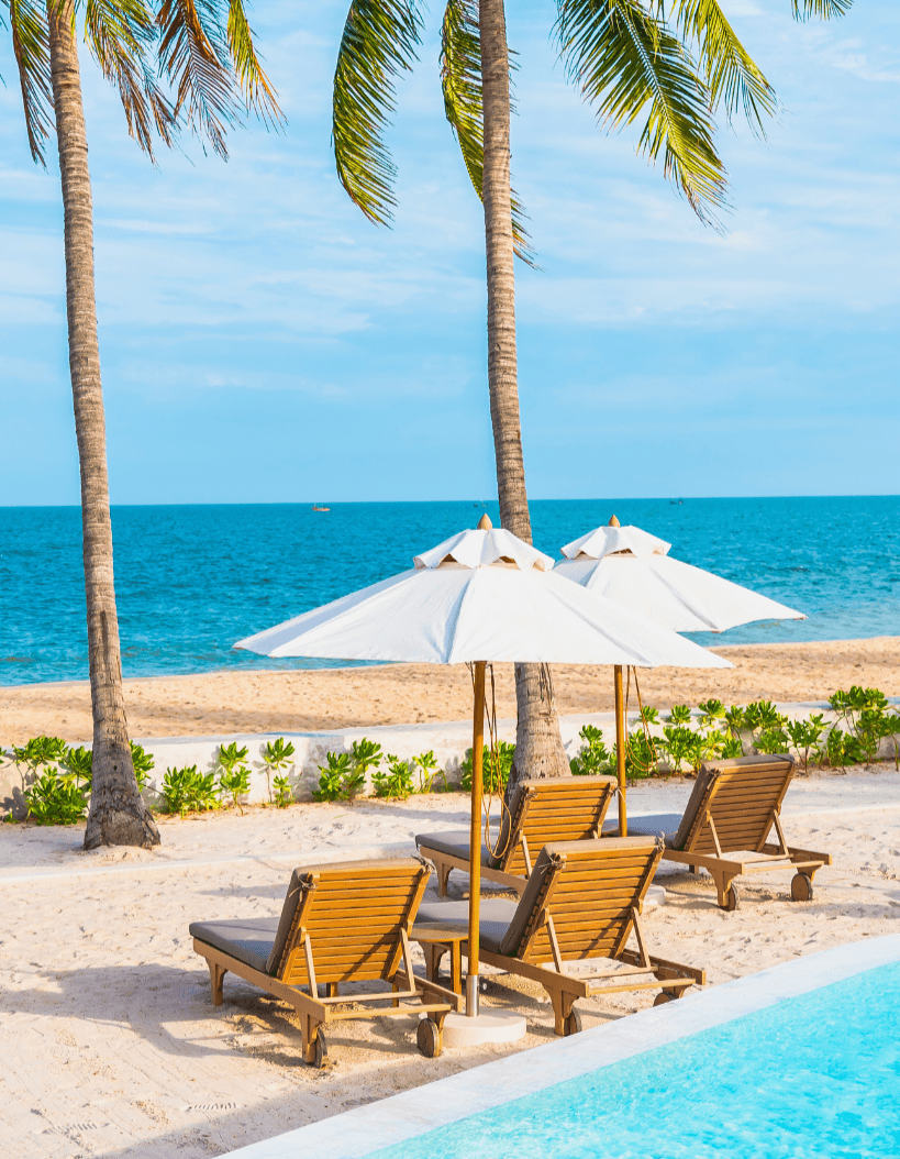 Beachfront property in the Dominican Republic with lounge chairs, palm trees, and ocean view.